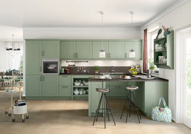 Schüller Canto "Shaker" kuhinja u zelenoj boji ("satin lak"), sa šankom i crnom radnom pločom, koja kombinuje tradicionalni stil i modernu funkcionalnost.