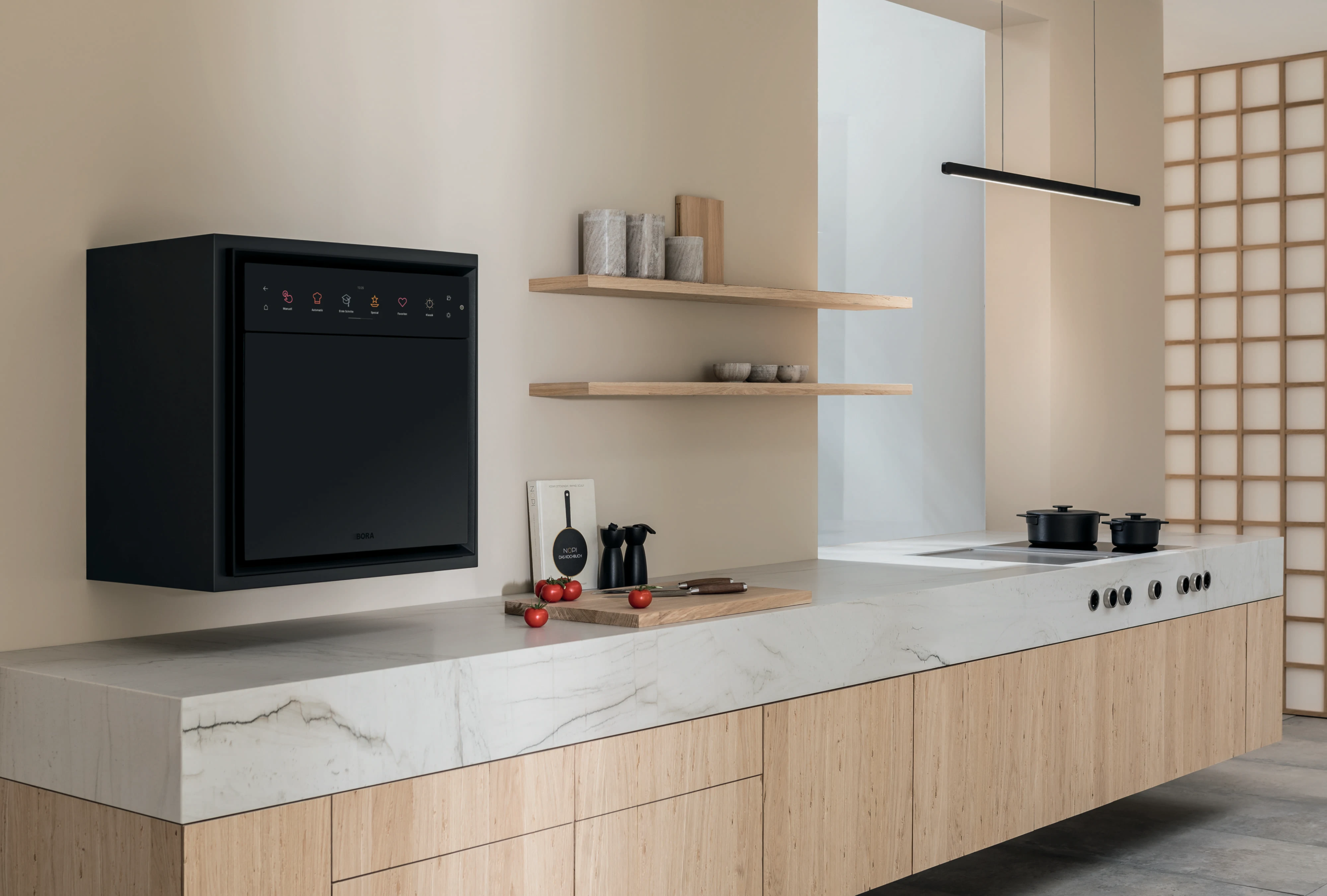 3 BORA X BO rerna kao elegantan element moderne kuhinje, u kombinaciji sa visećim svetlom i minimalističkim dizajnom radne ploče.