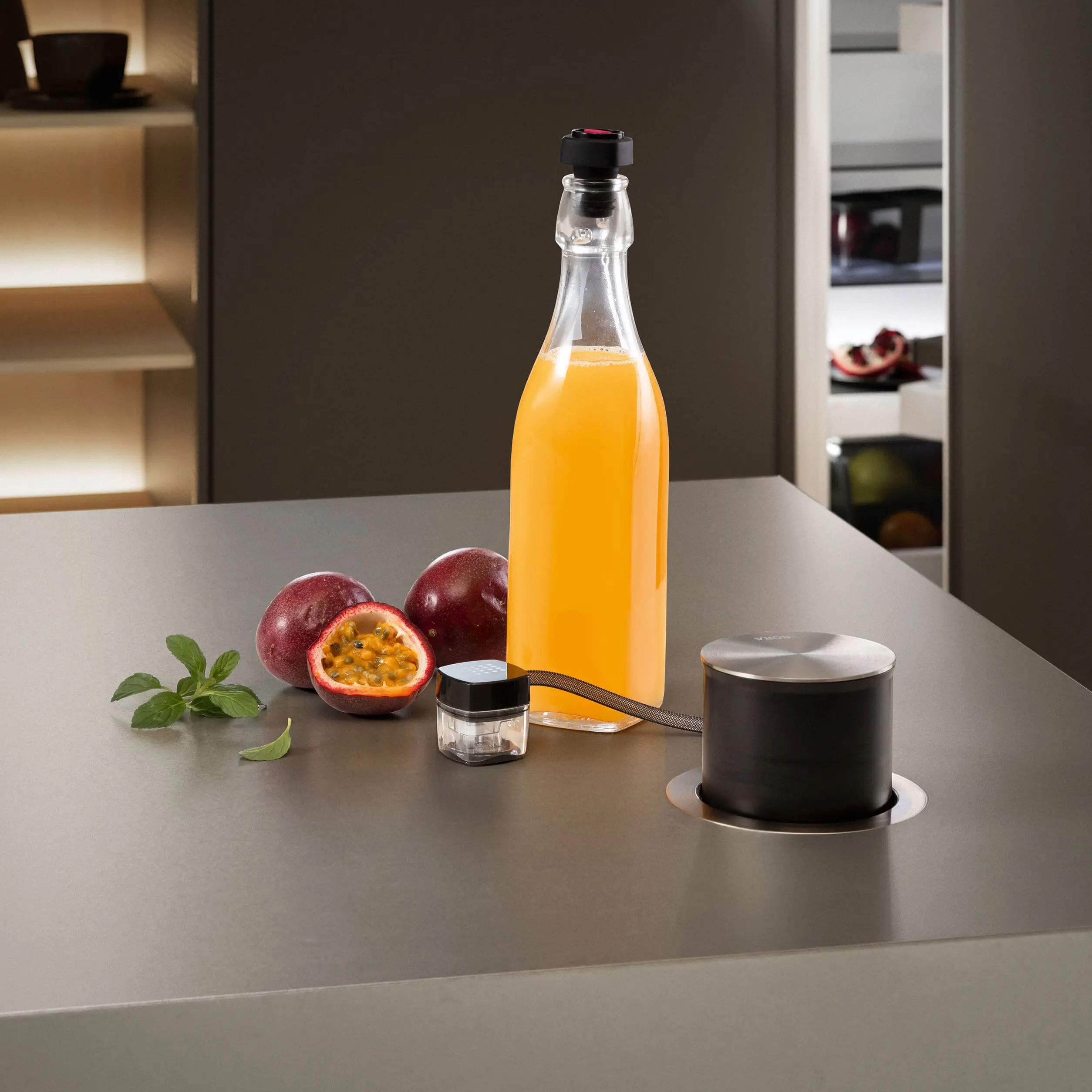 3 BORA QVac aparat za vakuumiranje, prikaz korišćenja sa flašom soka na radnoj površini.