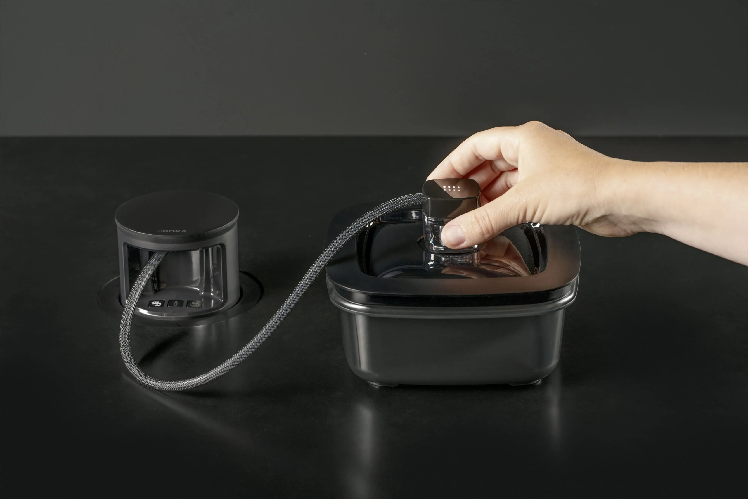 bora_qvac_marinierbox_hand BORA QVac sistem za vakuumiranje hrane, upotreba – ruka postavlja nastavak na poklopac posude tokom vakuumiranja.
