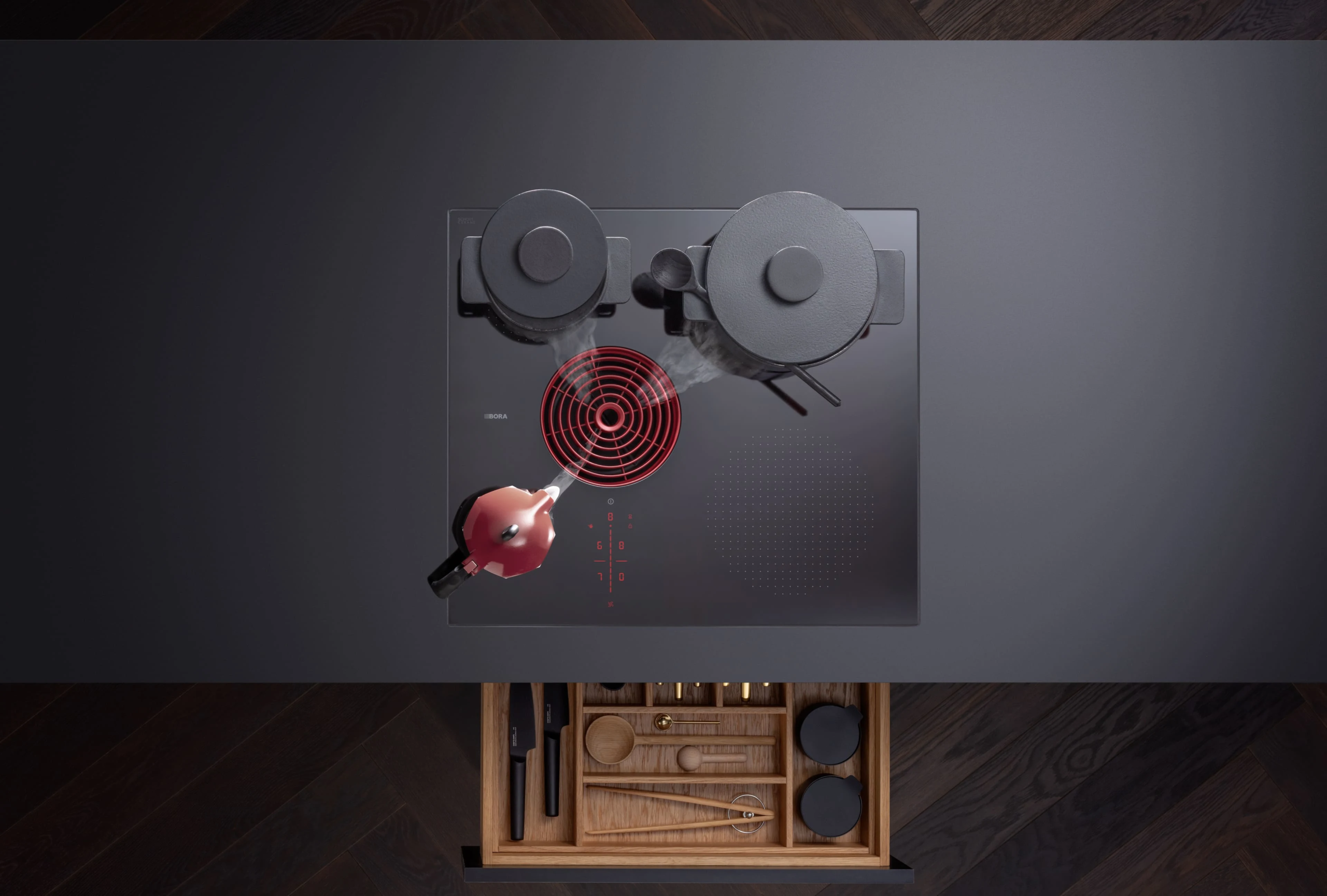 g0jnwuvzbpwxbsop5clq Pogled odozgo na BORA S Pure ploču u tamnoj kuhinji, sa tri posude i aktivnim crvenim ventilacionim otvorom.