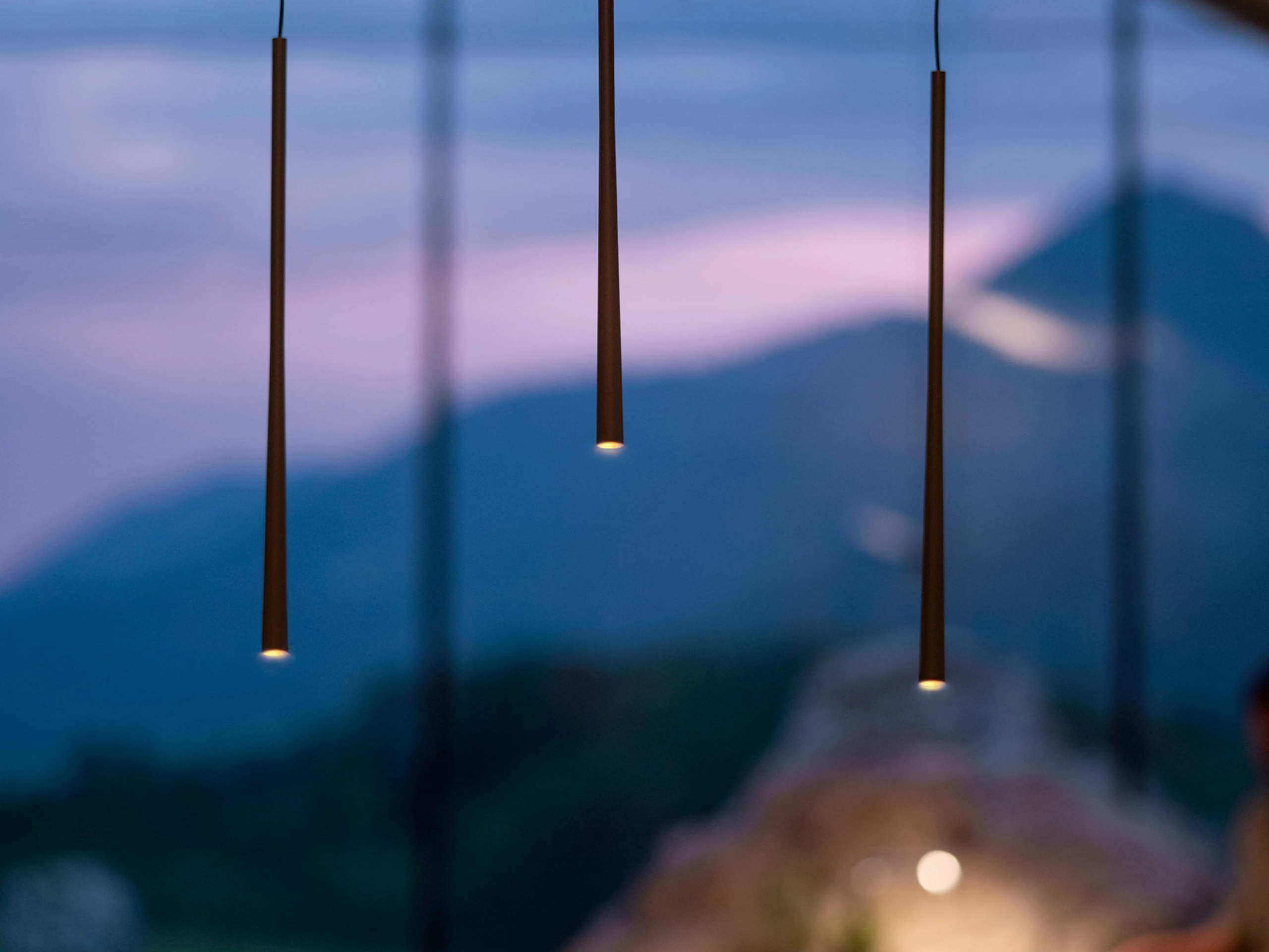 qc1nzb3hngr6fe0onzik Detalj BORA STARS Vertikal svetiljki – tri elegantne viseće cevi koje emituju meko, usmereno svetlo u večernjem ambijentu.