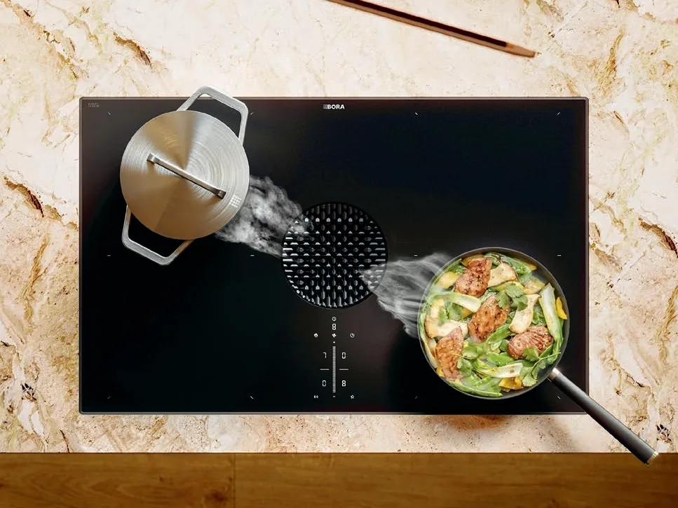 rpjmpqa4c61phmqwsed6 Pogled odozgo na BORA X Pure ploču u kuhinji sa mermernim pultom, sa dve posude.